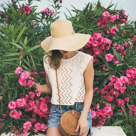 young-blonde-woman-sitting-near-blooming-oleander-GWEXALB.jpg